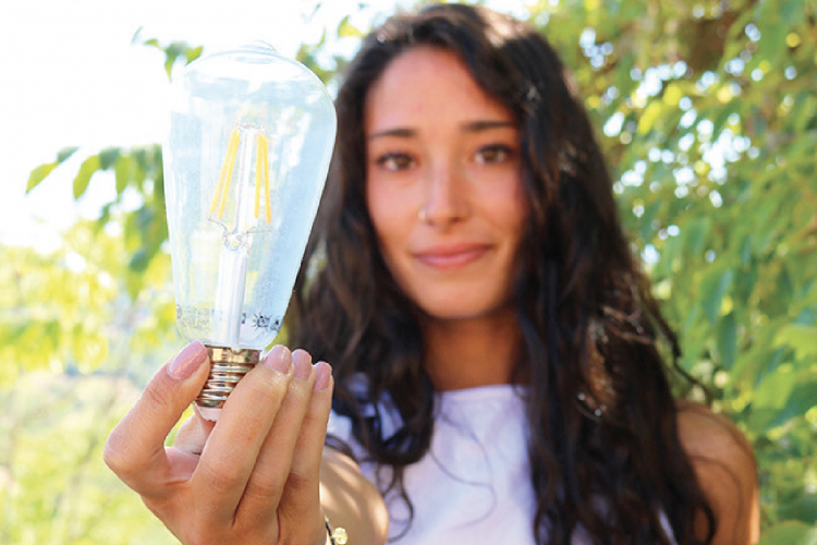 ragazza che reca in mano una lampadina