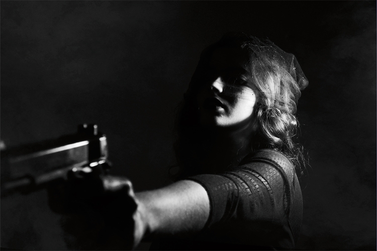 Dettaglio della locandina: donna che punta una pistola