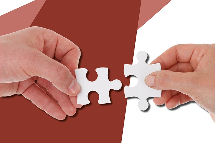 particolare della locandina: due mani che accostano delle tessere di un puzzle