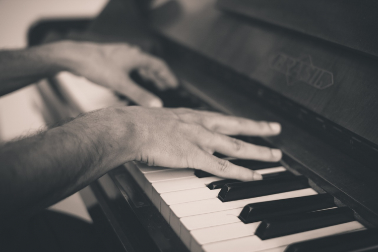 mani che suonano la tastiera di un pianoforte