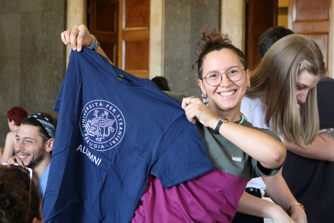 studentessa con in mano una maglietta col logo UniStraPg