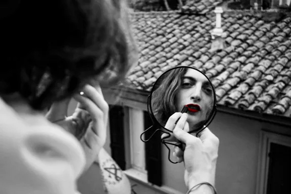 giovane uomo che si mette il rossetto