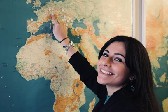 ragazza sorridente davanti a un planisfero